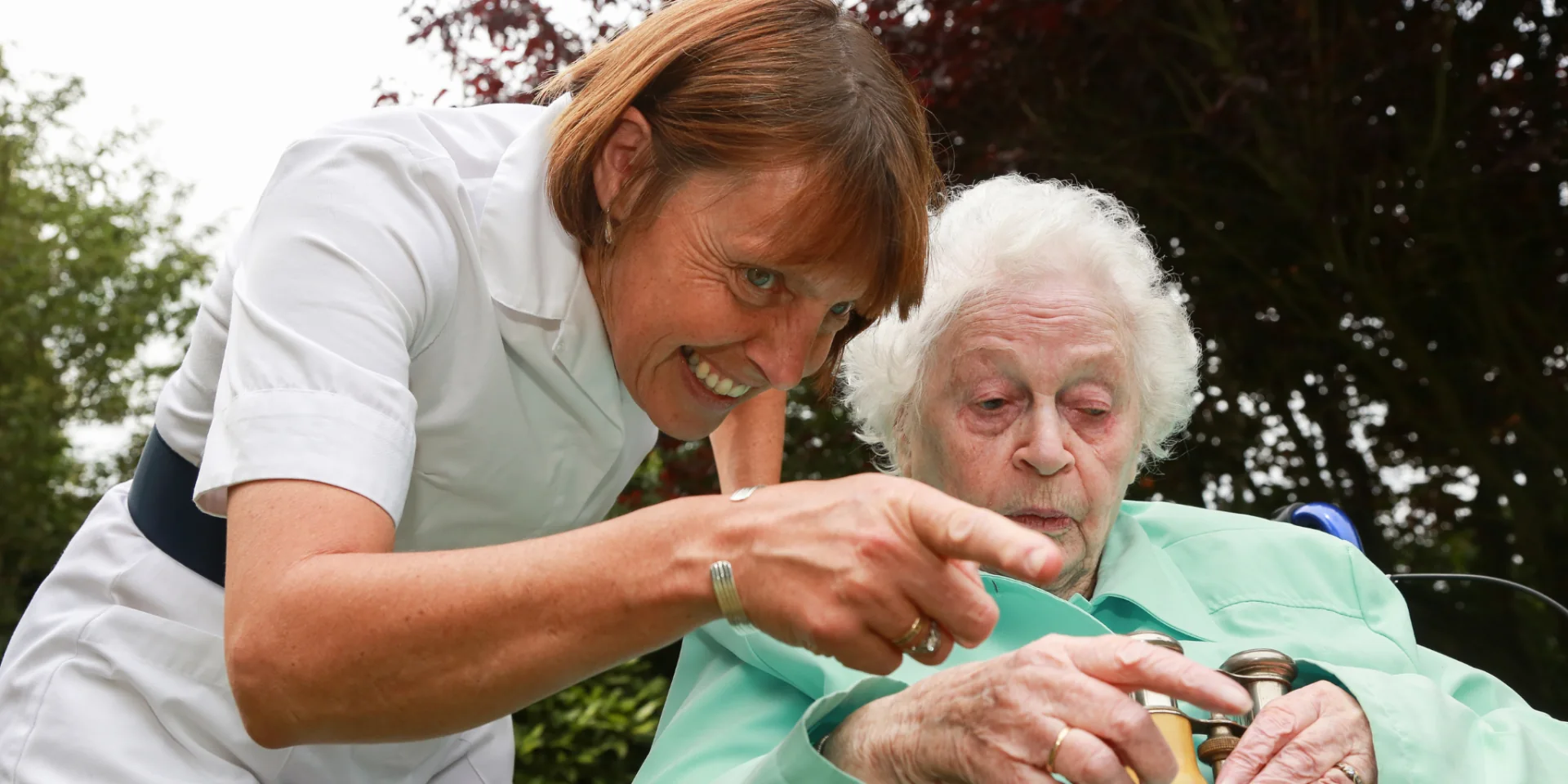 Betreuung Delme-Care Pflegekraft und Seniorin lachen gemeinsam im Garten – Delme-Care, ambulanter Pflegedienst in Delmenhorst