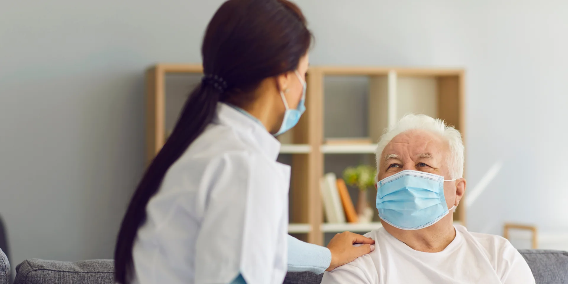 Pflegekraft mit Maske betreut einen Senior zuhause – Delme-Care, ambulanter Pflegedienst in Delmenhorst