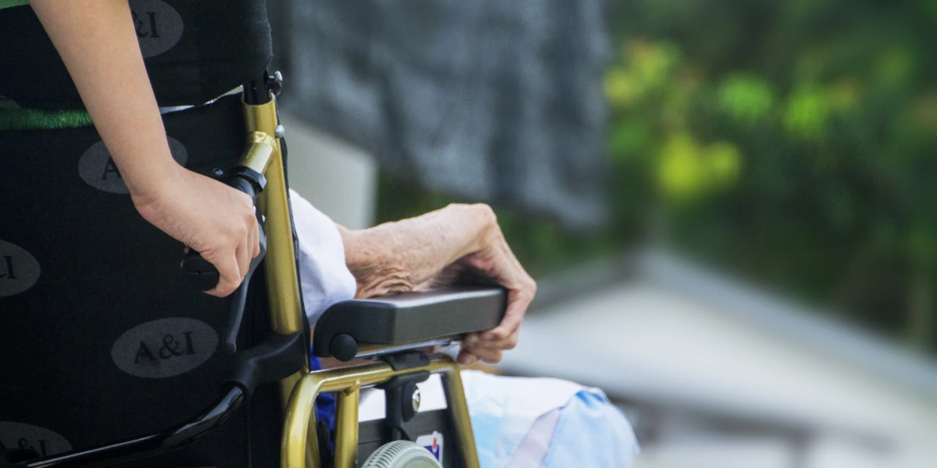 Pflegekraft schiebt eine Seniorin im Rollstuhl durch den Garten – Delme-Care, ambulanter Pflegedienst in Delmenhorst
